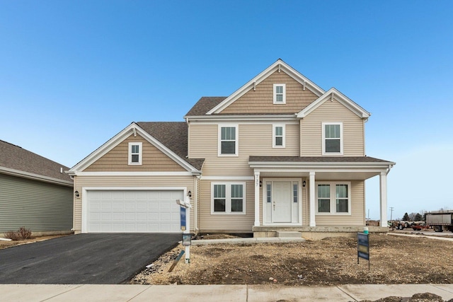 view of front of home featuring covered porch, driveway, and an attached garage