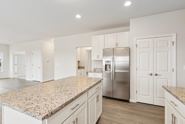 kitchen featuring light wood finished floors, recessed lighting, white cabinets, and stainless steel fridge with ice dispenser