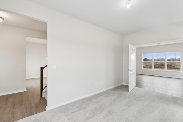 interior space featuring carpet, baseboards, and wood finished floors