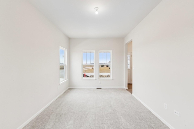 unfurnished room with carpet and baseboards