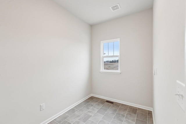 spare room featuring baseboards and visible vents