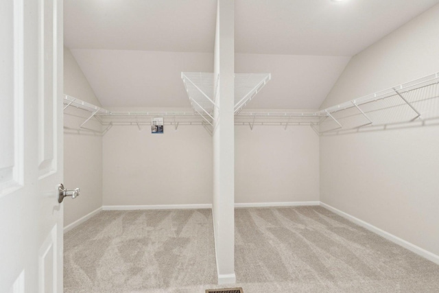 spacious closet featuring vaulted ceiling and carpet floors