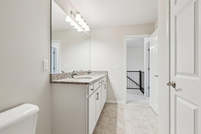 bathroom with toilet, baseboards, and vanity