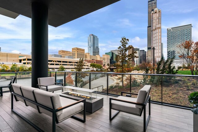 balcony featuring a view of city and an outdoor living space with a fire pit