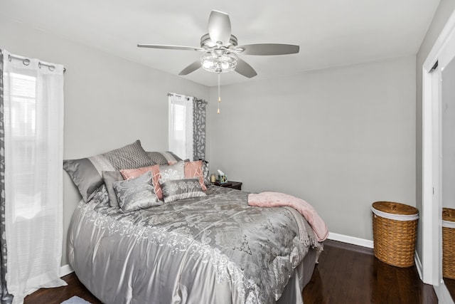 bedroom featuring wood finished floors, a ceiling fan, and baseboards