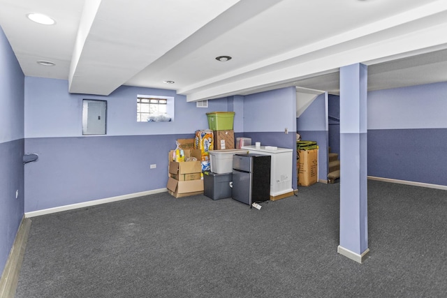 basement with carpet floors, electric panel, baseboards, and freestanding refrigerator