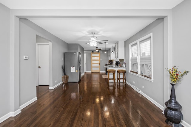 dining room with dark wood-style floors, ceiling fan, visible vents, and baseboards