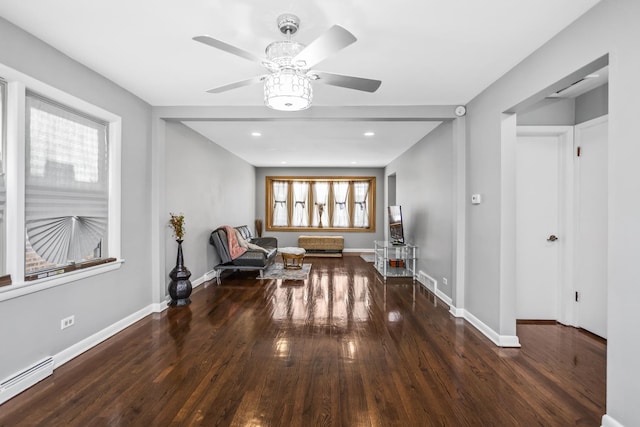 sitting room with a ceiling fan, a baseboard radiator, baseboards, and wood finished floors