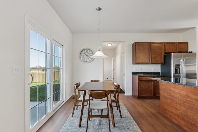 dining space with baseboards and dark wood finished floors