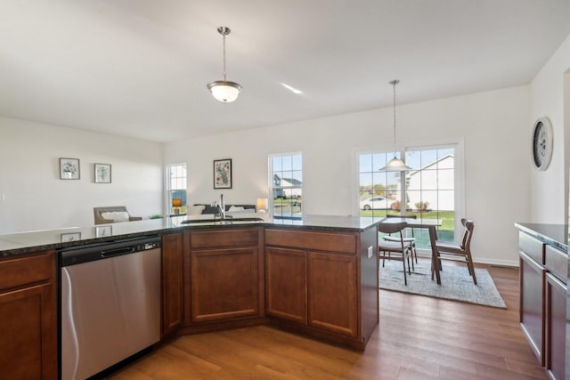 kitchen featuring a healthy amount of sunlight, dishwasher, light wood-style flooring, and a sink