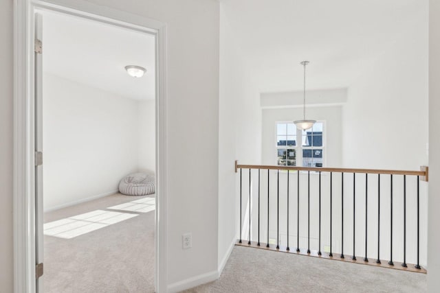 hallway featuring carpet flooring and baseboards