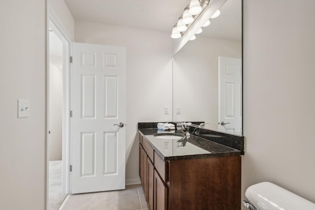 half bath featuring vanity, toilet, and tile patterned floors