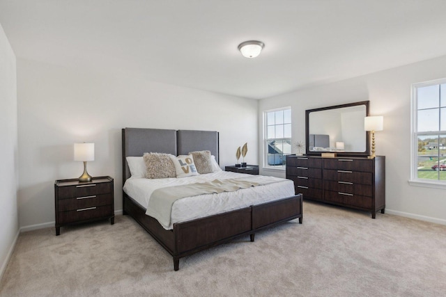 bedroom with light carpet and baseboards