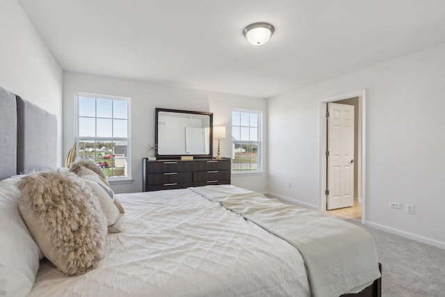 bedroom with baseboards and light colored carpet