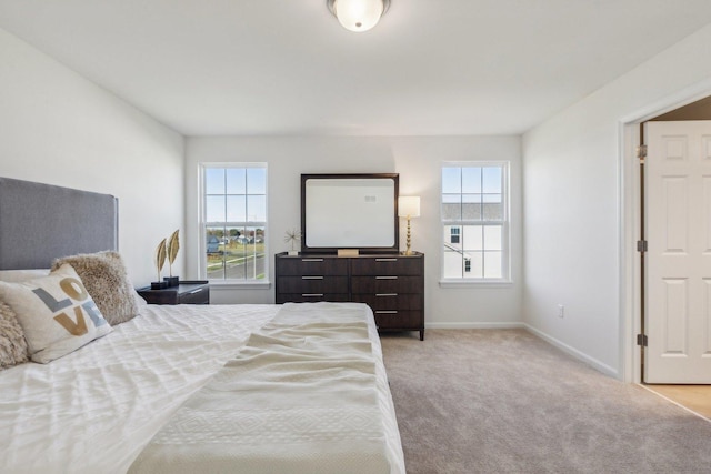 bedroom with light carpet and baseboards