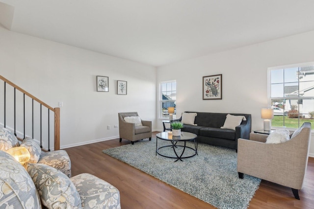 living area featuring a healthy amount of sunlight, stairway, and wood finished floors