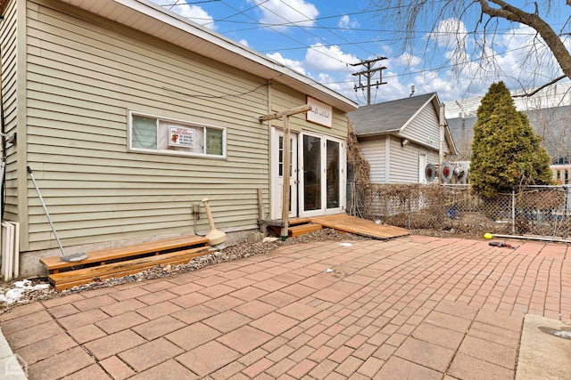 rear view of property with entry steps, a patio, and fence