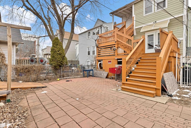 view of patio featuring fence, stairway, and a deck