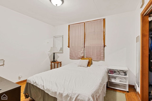 bedroom featuring wood finished floors and baseboards