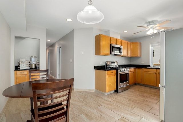 kitchen featuring a ceiling fan, recessed lighting, appliances with stainless steel finishes, dark countertops, and decorative light fixtures