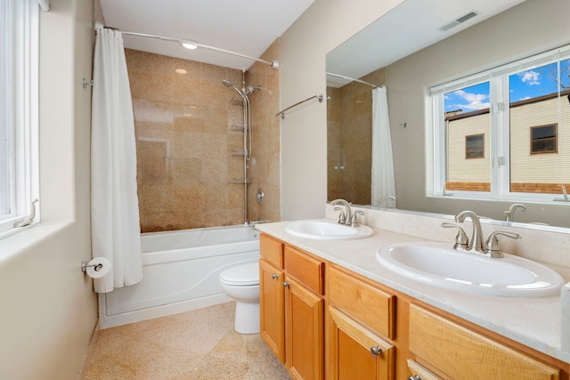 full bath featuring toilet, shower / bath combo, visible vents, and a sink