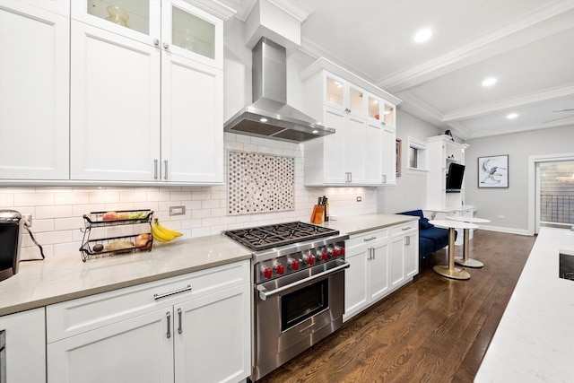 kitchen featuring white cabinets, dark wood-style flooring, premium range, crown molding, and wall chimney range hood