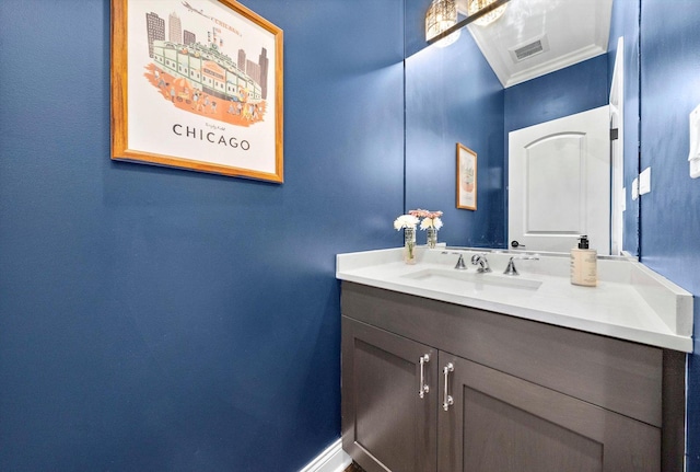 bathroom with visible vents, ornamental molding, vanity, and baseboards