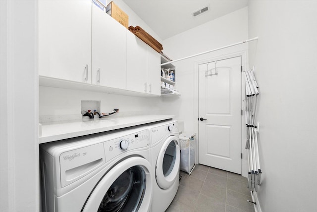 laundry room with visible vents, light tile patterned flooring, washing machine and clothes dryer, and cabinet space