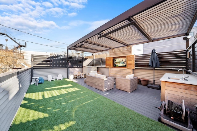 exterior space featuring a deck, fence, an outdoor hangout area, and a sink