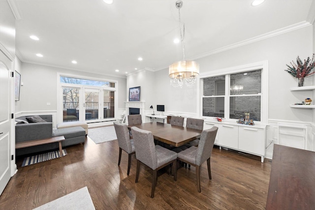 dining room with a fireplace, ornamental molding, and dark wood-style flooring