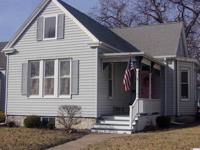 view of front of property featuring a shingled roof and a front yard