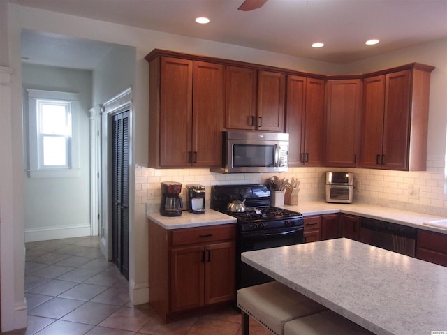 kitchen with recessed lighting, stainless steel microwave, black gas stove, and decorative backsplash