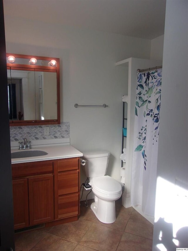 bathroom featuring curtained shower, toilet, vanity, backsplash, and tile patterned floors