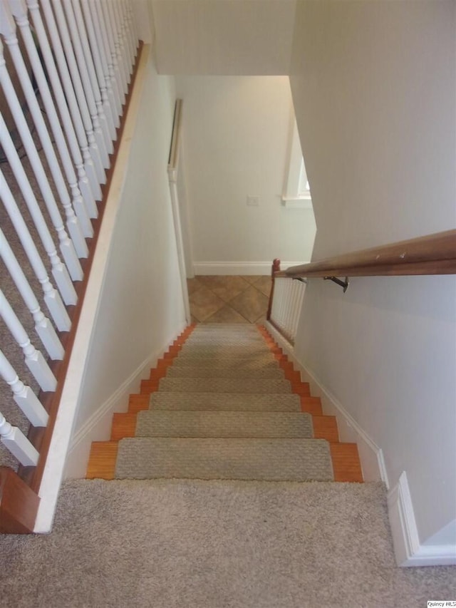 staircase featuring baseboards and tile patterned floors