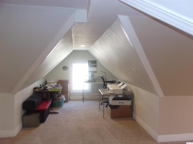 interior space with carpet floors, baseboards, and vaulted ceiling