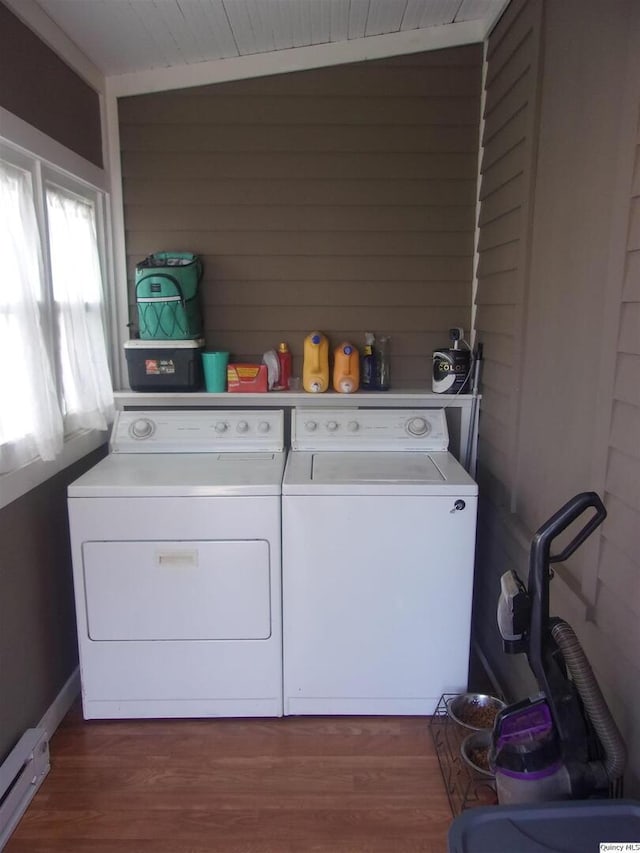 clothes washing area featuring laundry area, dark wood finished floors, baseboard heating, and washer and dryer