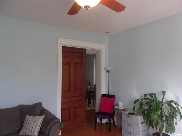 living area with ceiling fan and wood finished floors