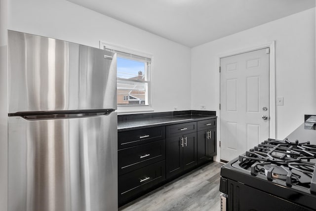 bedroom with light wood finished floors and freestanding refrigerator