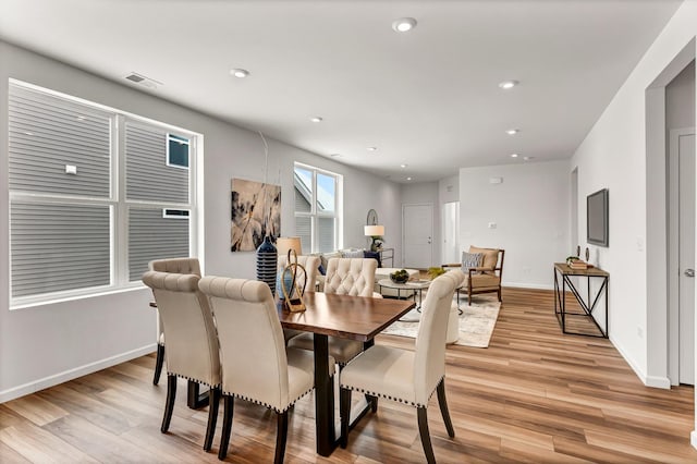 dining space with light wood finished floors, visible vents, and recessed lighting