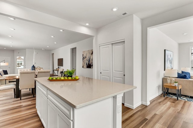 kitchen with light wood-style flooring, recessed lighting, white cabinetry, visible vents, and open floor plan