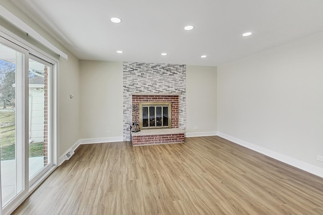 unfurnished living room with visible vents, baseboards, recessed lighting, a fireplace, and wood finished floors