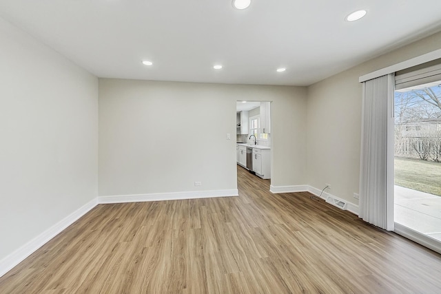 unfurnished room with recessed lighting, baseboards, and light wood-style floors