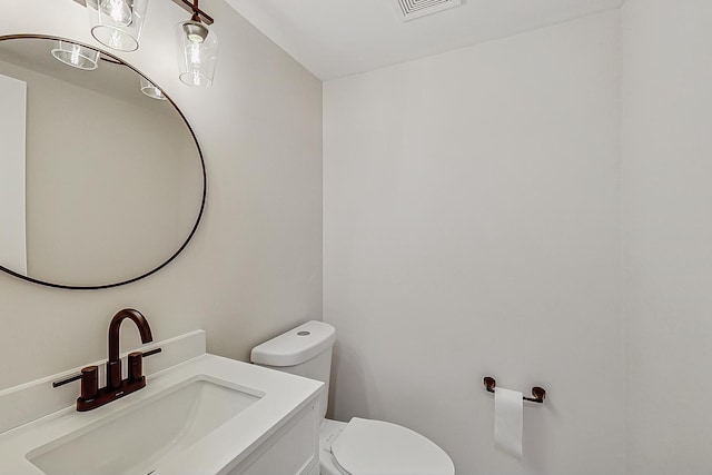 half bathroom featuring visible vents, toilet, and vanity