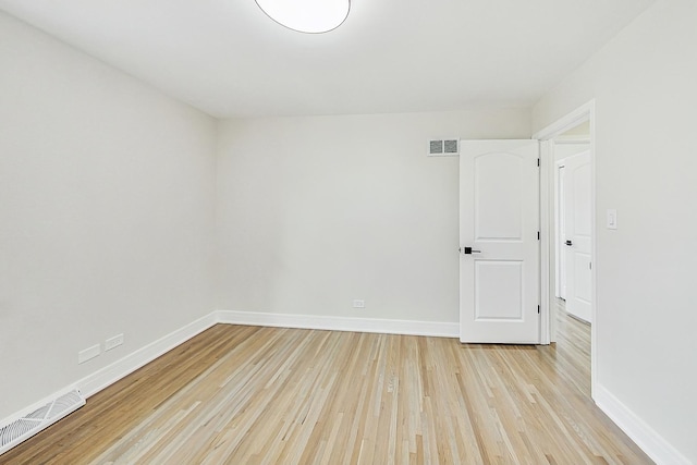 spare room featuring baseboards, visible vents, and light wood finished floors