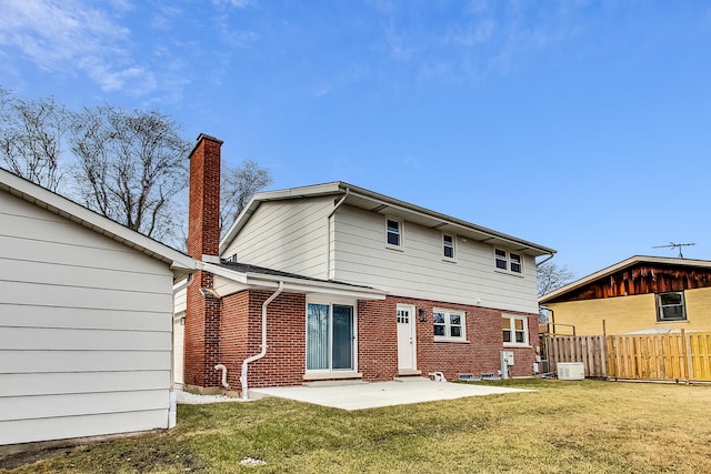 back of property with a yard, brick siding, central AC, and fence