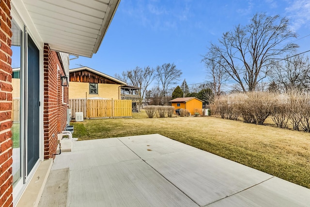 view of yard with a patio, an outbuilding, and fence