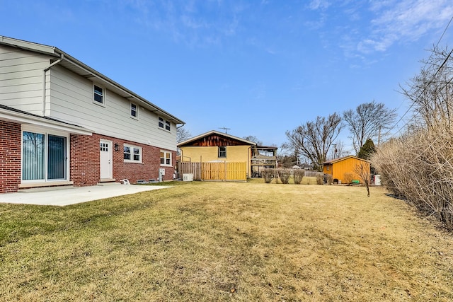 view of yard with a patio area, a shed, an outbuilding, and fence