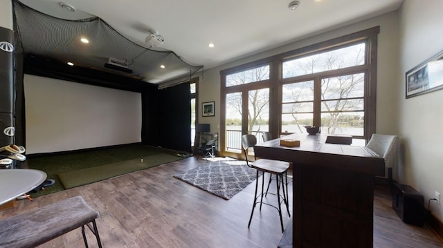 home theater featuring golf simulator, wood finished floors, and recessed lighting