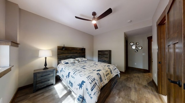 bedroom featuring vaulted ceiling, wood finished floors, a ceiling fan, and baseboards