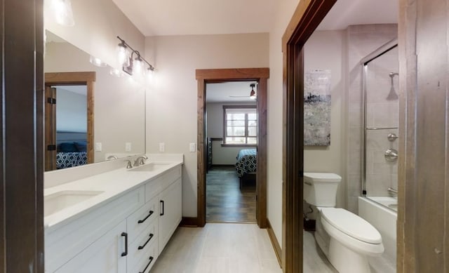 full bathroom with a sink, double vanity, toilet, and connected bathroom